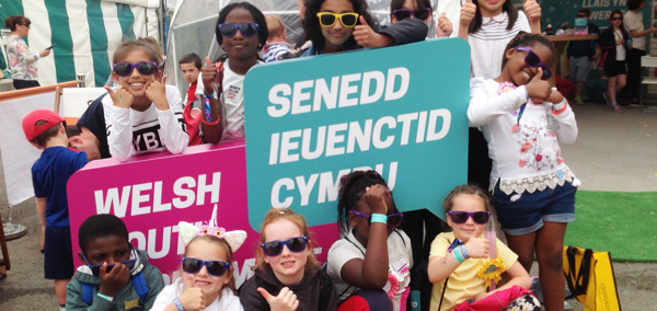 Plant yn dal arwyddion Senedd Ieuenctid Cymru i fyny